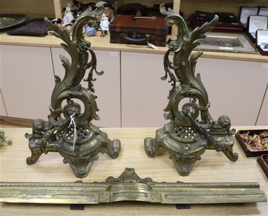 A Louis XV style cast brass rococo kerb and two fire dogs height 47.5cm
